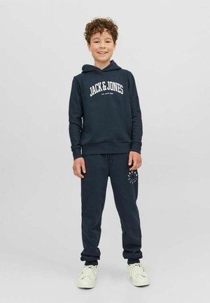 Conjunto de sudadera con capucha y pantalones de chándal en azul marino, con el logo blanco de "JACK & JONES" y detalles a juego en los pantalones. Material de algodón suave.
