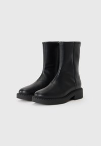 Sorte lær ankelboots med en glat overflade, rund tå og lynlås på siden; tyk sort sål med tekstureret kantdetalje.