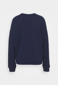 Tmavě modrá mikina s kulatým výstřihem, spadlými rameny a žebrovanými manžetami. Měkká textura a volný, pohodlný střih. Zobrazen pohled zezadu.