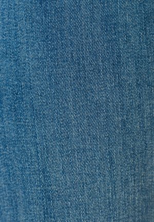 Primo piano di tessuto di denim blu classico che mostra la dettagliata trama diagonale a spina di pesce.