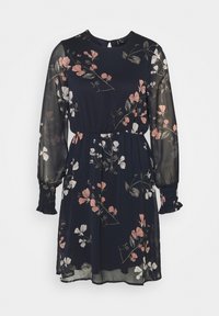 Robe florale navy à manches longues en tulle, avec des poignets froncés et une taille élastiquée. Présente des motifs de fleurs roses et blanches sur un fond sombre.