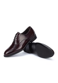 Chaussures de ville pour hommes en cuir marron avec une finition lisse, un design à lacets, un bout pointu, des coutures sur le bout et une semelle en caoutchouc plate.