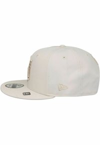 Casquette blanche à visière plate, texture en tissu, logo brodé à l'avant et accents sur les côtés ; design structuré avec des trous de ventilation.