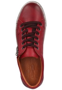 Rode leren sneaker met een ronde neus, zwart-rode gemusterde veters, zijrits en een bruine getextureerde binnenvoering.