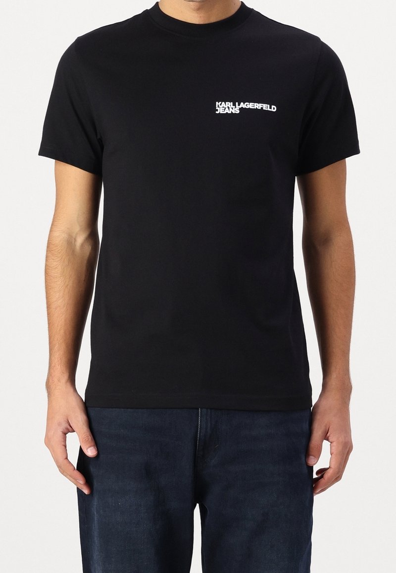 Černé triko s krátkým rukávem vyrobené z bavlny. Na levé straně hrudi se nachází bílé logo "Karl Lagerfeld Jeans". Jednoduchý design s kulatým výstřihem.