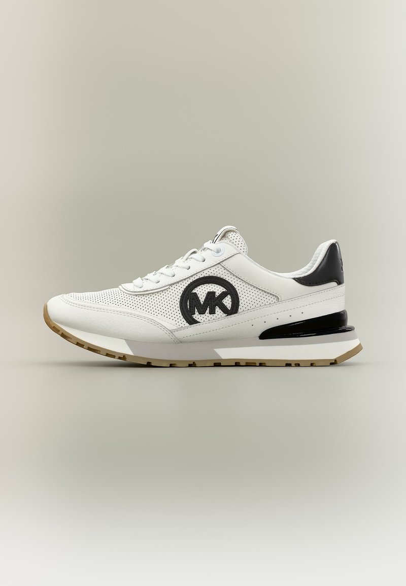 Baskets de sport blanches en cuir perforé, logo Michael Kors noir sur le côté, détail noir au talon et semelle brun clair.
