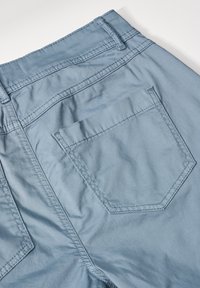 Helles, blaues Baumwollhose mit einer Rückentasche und doppelter Naht. Glatte Textur mit einem leicht glänzenden Finish und minimalistischem Design.
