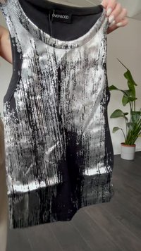 Black and silver sleeveless tank top featuring a textured design with vertical stripes, rounded neckline, and ribbed edges.