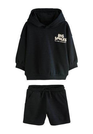 Black hooded sweatshirt with "Big Smiles All Day Everyday" text on chest, paired with black elastic waist shorts with drawstring and pockets.