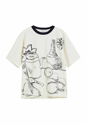 Cream T-shirt features black line drawings of a teapot, fruits, and flowers. It has a contrasting navy round neckline and short sleeves.