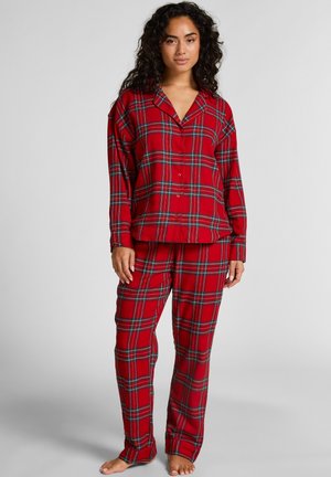 Pyjamas écossais rouges en tissu brossé, comprenant un haut à boutons avec col et manches longues, accompagnés d'un pantalon assorti.