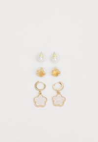 Conjunto de pendientes en tono dorado que presenta bases de pin de cristal claras con perlas, diseños florales y formas de flores colgantes con una textura suave.