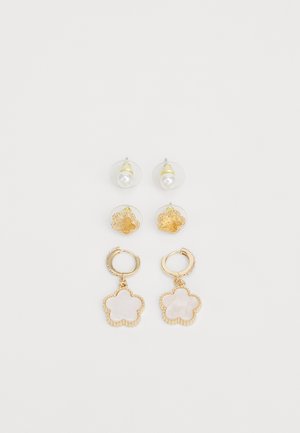 Set di orecchini color oro con retro in cristallo trasparente, perle, design floreali e forme di fiori pendenti con una superficie liscia.