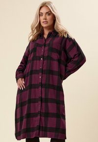 Abito camicia a quadri bordeaux e nero, con maniche lunghe, doppie tasche frontali e una vestibilità rilassata con colletto.