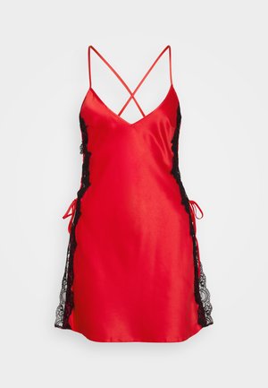 Červené saténové šaty na ramínka s černými krajkovými stranami, nastavitelnými křížovými ramínky, výstřihem do V a bočními vázankami, které vytvářejí elegantní kontrast v designu.