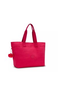 Borsa tote di colore rosa acceso con due maniglie robuste, finitura in tessuto liscia, logo in rilievo sulla parte frontale e un charm a pom-pom morbido attaccato sul lato.