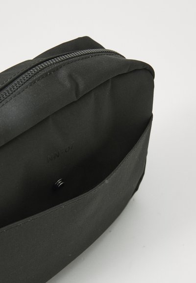 Funda de tela negra con cierre de cremallera, que presenta un exterior suave y un diseño rectangular simple. El interior está forrado con material negro.