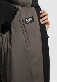 Parka in Grau und Schwarz, mit einem glatten, strukturierten Stoff, Seitentaschen und einem Etikett mit "Khujo original for a few" Branding.