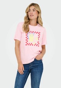 Roze katoenen T-shirt met korte mouwen, voorzien van een grafisch ontwerp van een gele drank in een kan met citroenschijfjes, omrand door een rode geruite rand.