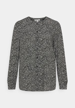 Blusa preta de mangas longas com um padrão salpicado branco, apresentando um decote redondo e uma ligeira frunçe na cintura para um ajuste descontraído.