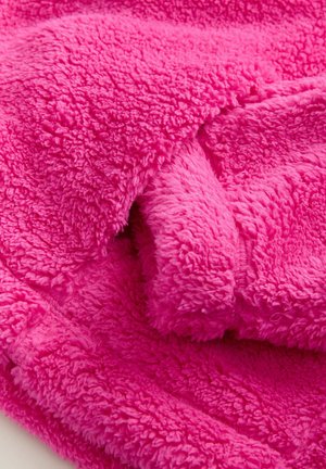Fleece-Decke in leuchtendem Pink, weiche Textur mit einer plüschigen, flauschigen Oberfläche und gekräuselten Fasern, mit einer glatten Kantennaht.