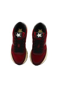 Sneaker in suede rosso con accenti neri, punta tonda, lacci neri e suola beige. Logo a stella sulla linguetta in oro su sfondo nero.