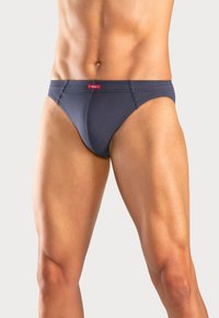 Dunkelblaue Herrenunterhosen aus Baumwolle mit einem roten Etikett am Bund. Das Design ist eng anliegend mit gestickten Details und minimalem Schnitt.
