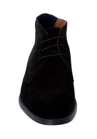 Bottes noires en suede jusqu'à la cheville avec une texture lisse, un bout rond et des accents en cuir tan contrastants. Elles présentent des lacets et une semelle en caoutchouc noire.