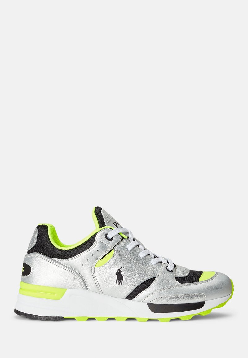 Chaussure de sport argentée avec accents noirs, détails vert néon, dessus en cuir texturé et mesh, semelle intermédiaire blanche épaisse et semelle extérieure en caoutchouc.