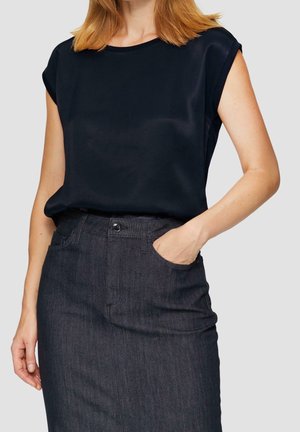 Granatowy, krótki top z gładkiego materiału, zestawiony z ciemną spódnicą dżinsową z przednią kieszenią i zapięciem na guziki.