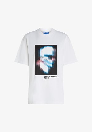 Bijela majica kratkih rukava sa izobličenom plavom i ružičastom digitalnom slikom lubanje i tekstom "KARL LAGERFELD JEANS" ispod na prednjoj strani.