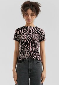Korte mouwen top in roze en zwarte zebraprint, met een ronde halslijn en een soepele textuur, gecombineerd met hoge taille donkere jeans.