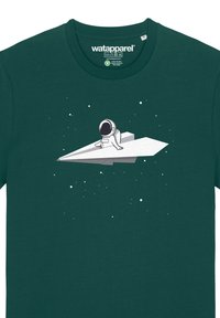 Grünes Baumwoll-T-Shirt mit einem Grafikdesign eines Astronauten, der auf einem weißen Papierflugzeug sitzt, mit kleinen weißen Sternen im Hintergrund.