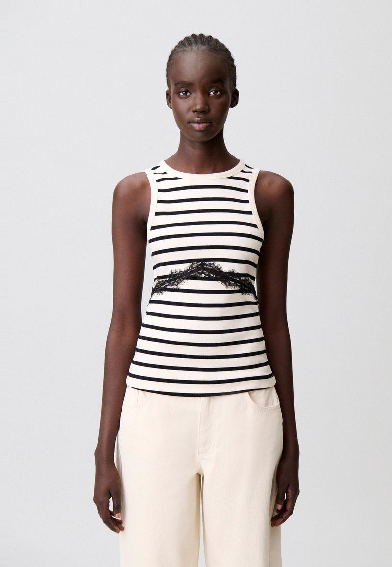 Canotta a righe in crema e nero, con un dettaglio in pizzo nero in vita. Tessuto morbido con design aderente e scollo rotondo.