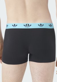 Czarne bokserki z jasnoniebieską elastyczną talią ozdobioną czarnymi logo trzylistnej koniczyny Adidas. Gładka tkanina o przylegającym kroju.