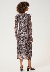 Kirkas, pitkähihaiset mekko, jossa on leopardikuosi beige- ja mustissa sävyissä, nilkkapituinen, suorahko malli ja viehättävää rypytystä vyötäröllä.