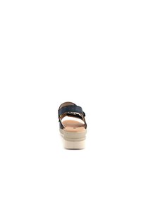 Sandal blu navy con due ampie cinghie e una suola piatta di un beige chiaro. Materiale liscia con dettagli minimi e design aperto sul retro.