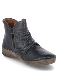 Bottines noires en cuir avec un design froncé, fermeture éclair sur le côté, tige texturée et semelle en caoutchouc marron légèrement courbée à l'avant.