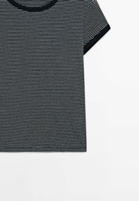 Striped t-shirt with a crew neck and short sleeves. Features alternating black and white stripes. Cotton material with a smooth texture.