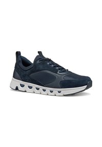 Baskets bleu marine avec tige en daim et cuir, semelle extérieure blanche avec des découpes circulaires, lacets plats et languette au talon.
