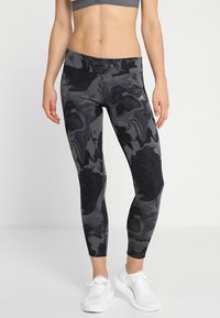 Black and gray athletic leggings with a marble pattern, high waistband, and snug fit, made from a stretchy, moisture-wicking material.