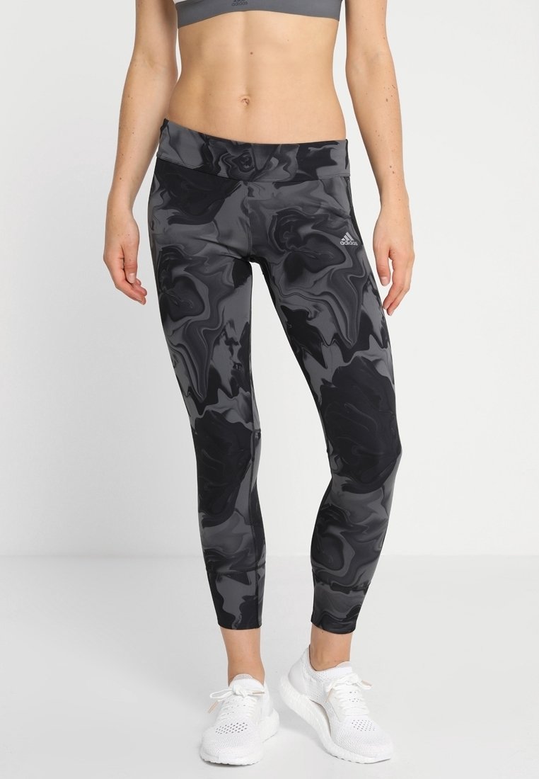 Black and gray athletic leggings with a marble pattern, high waistband, and snug fit, made from a stretchy, moisture-wicking material.