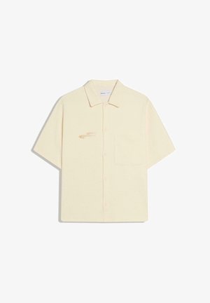 Chemise beige à manches courtes avec boutons, col, poche avant côté gauche et logo brodé discret sur la poitrine droite.