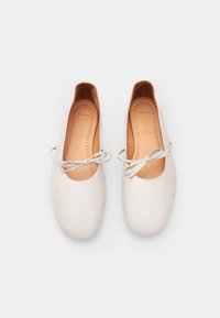 Białe skórzane baleriny z okrągłym noskiem, miękką wewnętrzną wyściółką oraz dekoracyjną kokardką na każdej z nich. Gładka faktura i prosty design.