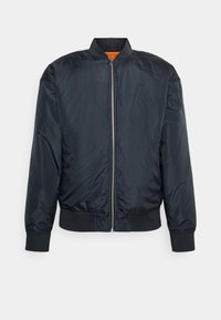 Blouson bomber noir avec fermeture éclair argentée à l'avant, col, poignets et bandeau côtelés, et doublure intérieure orange visible au niveau du cou.