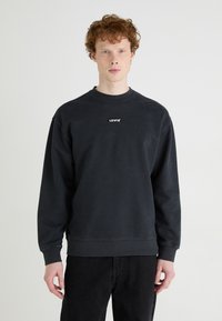 Mörkgrå sweatshirt med rundad halsringning och långa ärmar. Har en liten svart Levi's-logotyp på framsidan. Tillverkad i bomullsblandning.