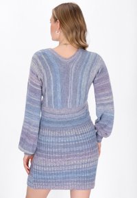 Strickkleid mit V-Ausschnitt und langen Glockenärmeln. Farbverlauf in Blau- und Lilatönen mit gerippter Textur und horizontalen Streifen.