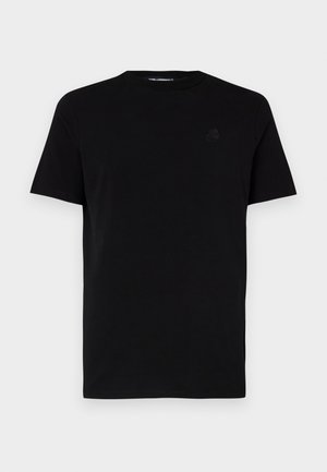 T-shirt preto de manga curta feito de algodão, com decote redondo e um logotipo em relevo subtil no lado esquerdo do peito. Textura suave.