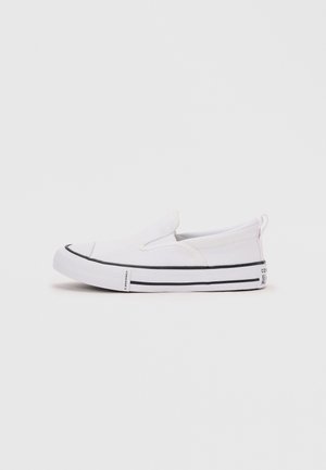 Fehér vászon slip-on sportcipő fekete csíkkal a talpon és húzófüllel a saroknál, semleges háttéren, oldalnézetben.