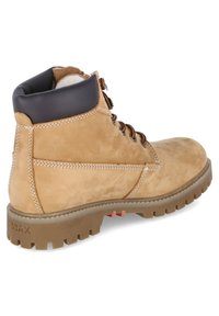 Tan leren wandelschoen met een gevoerde zwarte kraag, stevige veters en een gestructureerde zool met diepe profielen voor grip.